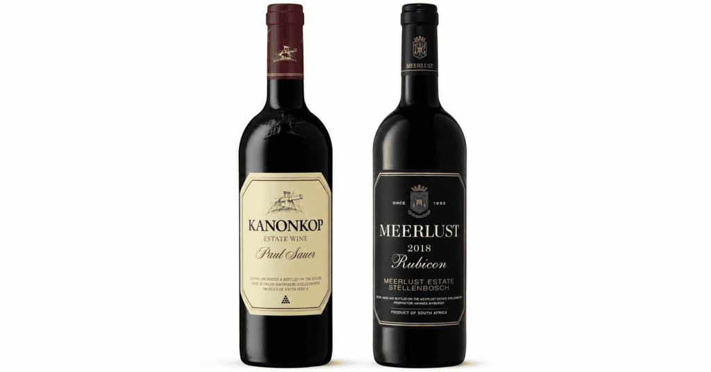 Two bottles of red wine stand side by side: Kanonkop Estate Wine and Meerlust Estate Rubicon 2018, highlighting the classic Meerlust Rubicon vs Kanonkop Paul Sauer comparison with their distinct labels.