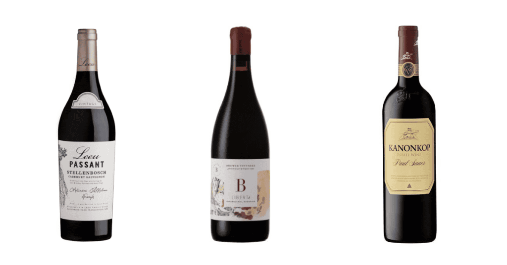 Three bottles of top vintage 2021 South African wine—Leeu Passant, Liberté, and Kanonkop Paul Sauer—are displayed side by side on a white background.